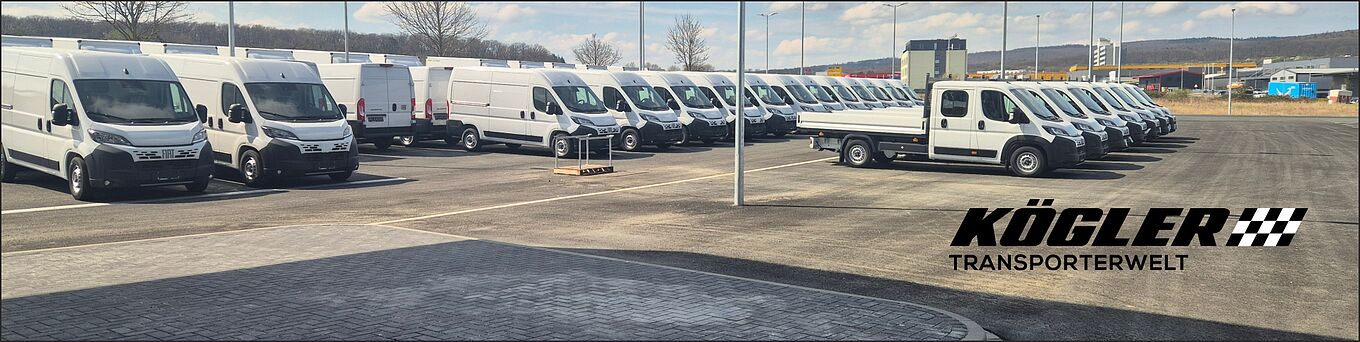 Eine große Auswahl an Transportern parken vor unserem Autohaus